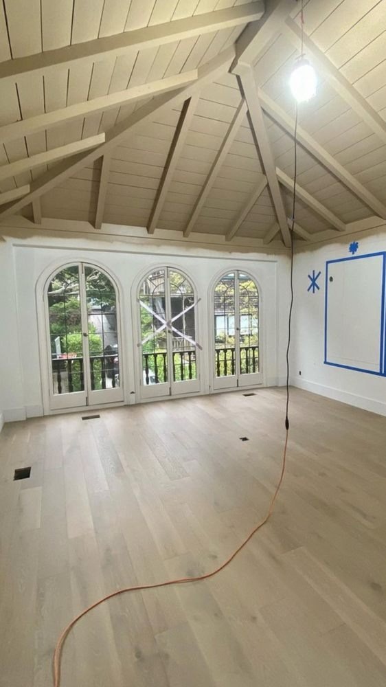 Empty room with arched windows, a vaulted ceiling and a new floor