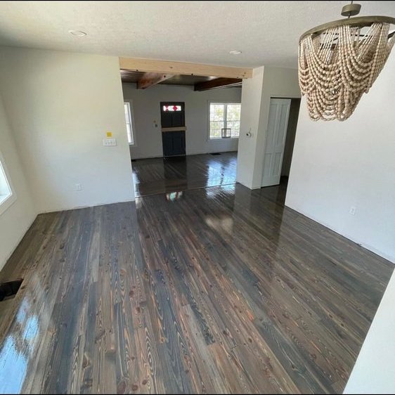 Refinished dark hardwood floor in an open room
