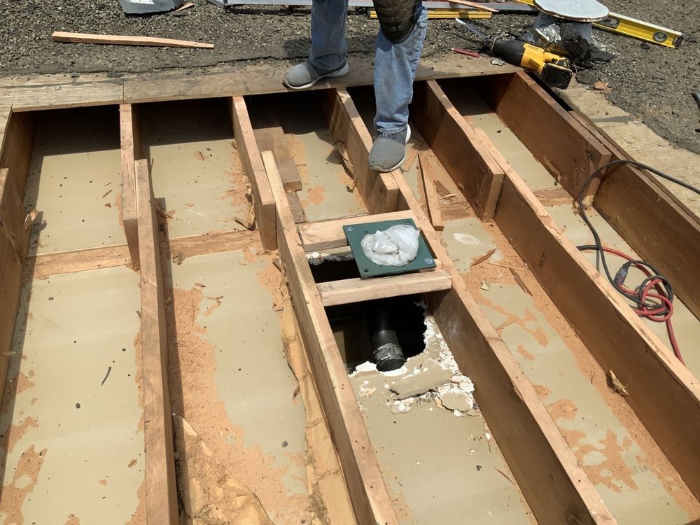 Floor framing and plumbing pipe exposed during a repair