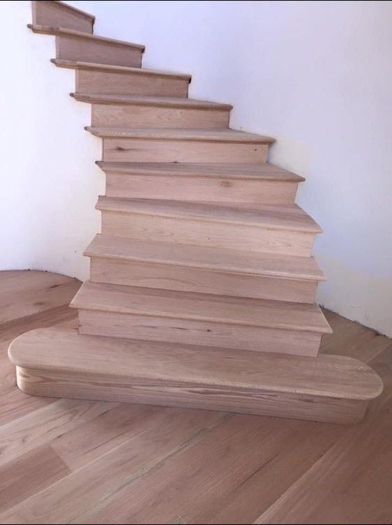 New wood staircase against a white wall