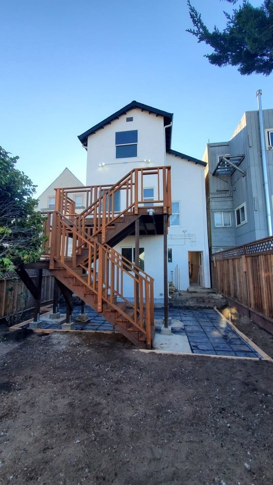 New house with a wood-framed exterior stair in the yard
