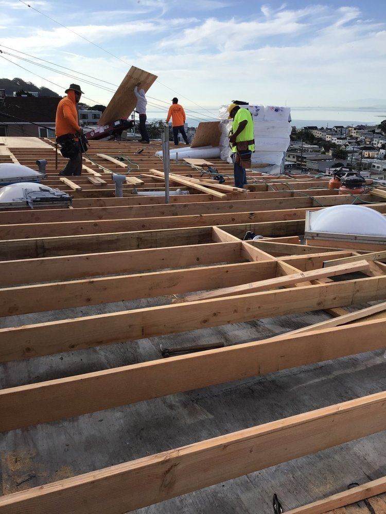 Crew working on floor joists with a view over the city