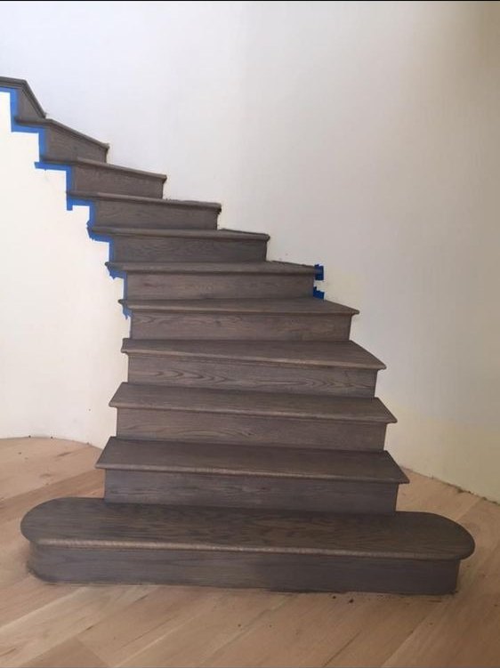Dark-stained staircase with a painted wall