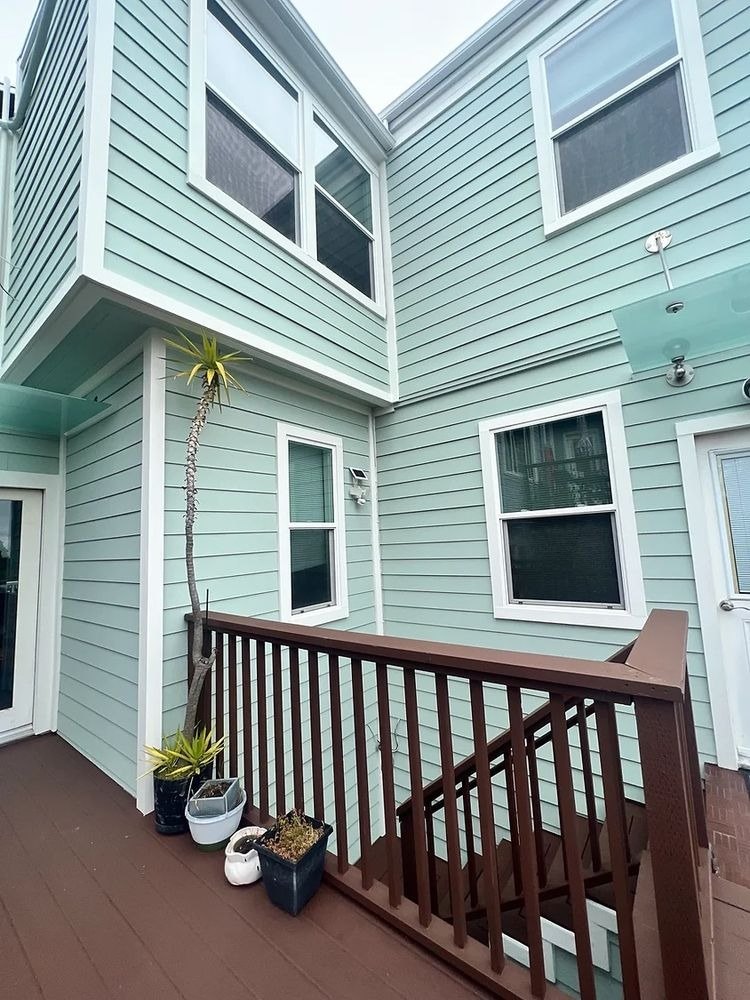 Green house with a new deck and railing