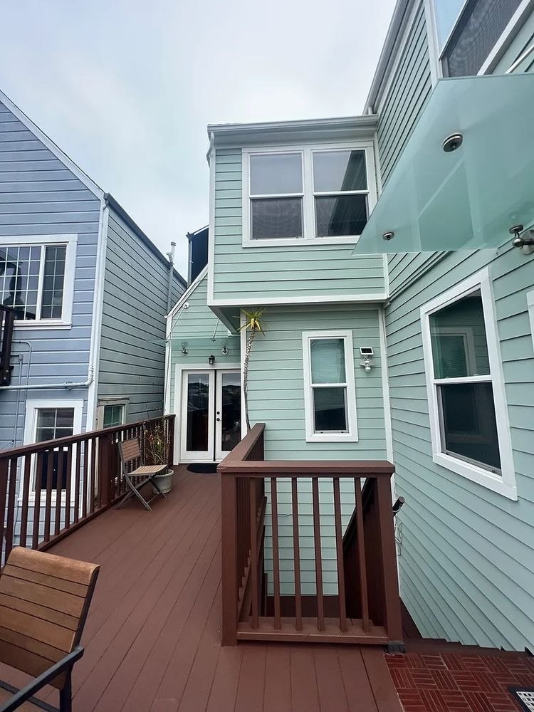 Rear of a green house with a deck
